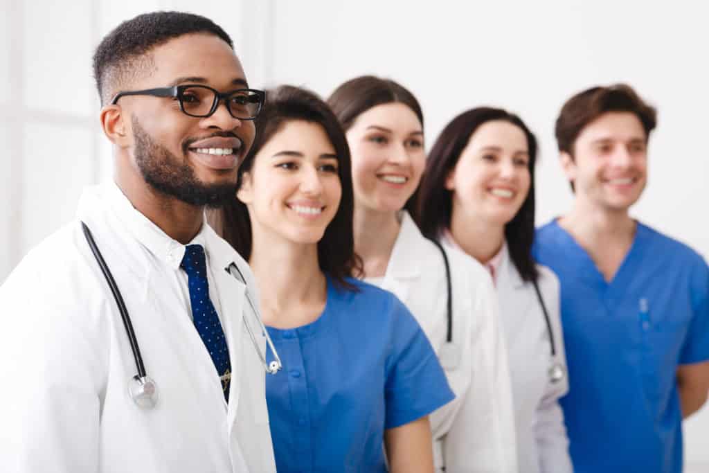 Doctor Standing In Row With Team