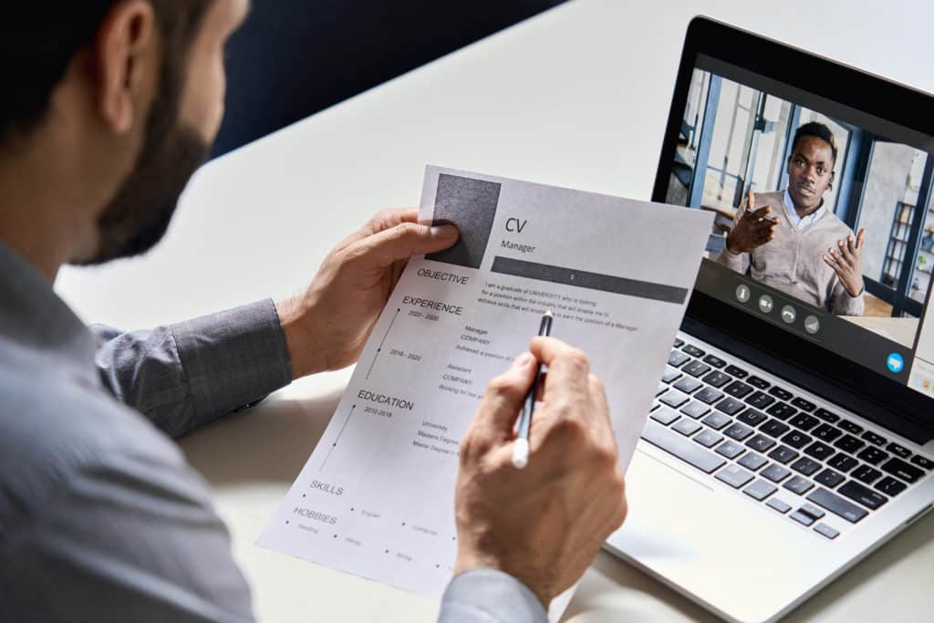 Man holding resume during virtual interview