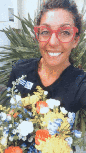 Nurse Lizzie in scrubs holding a bouquet of flowers
